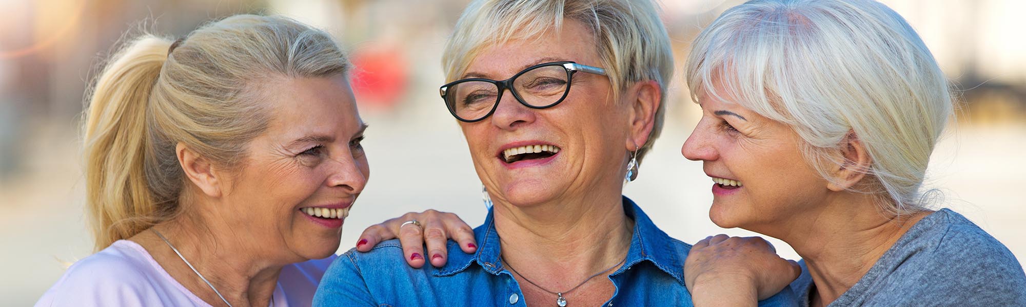 Group of smiling senior women standing outside Assisted Living or Memory Care at Aravilla Sarasota